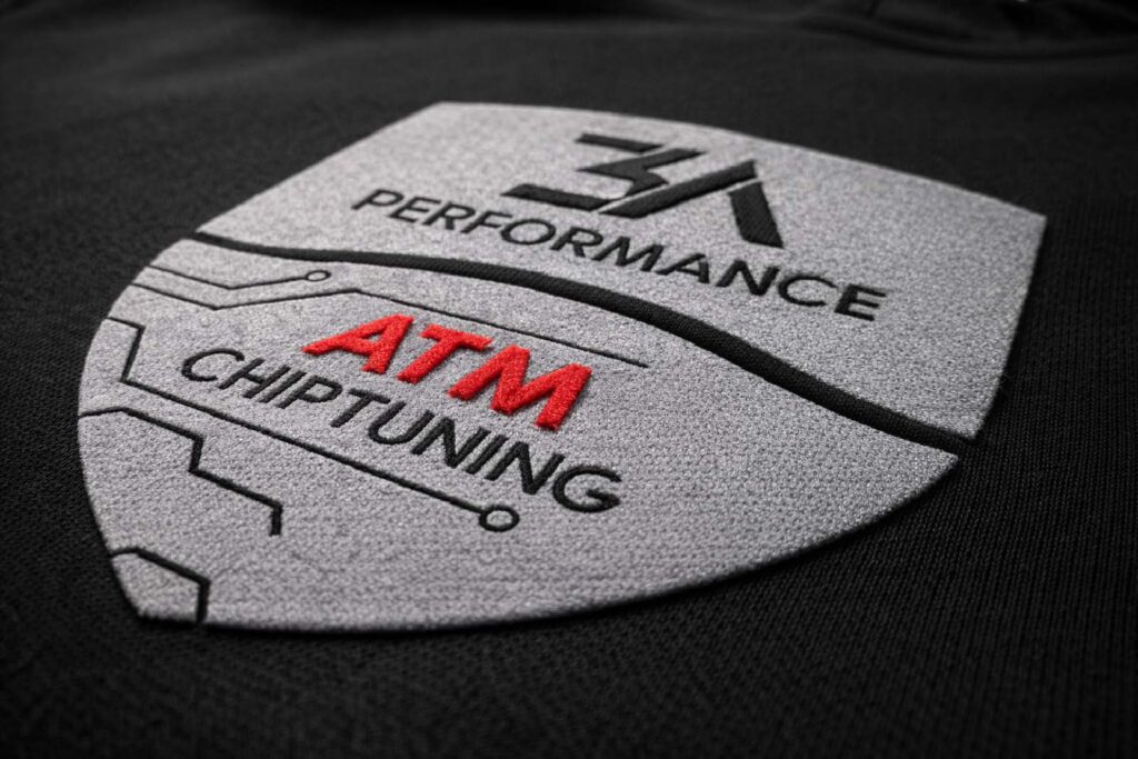 Kombinacija sive i crvene flok folije sa izraženim 3D efektom na tekstilu. Premium reljefni preslikač za upečatljiv izgled logotipa.